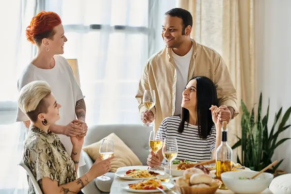 Um grupo diversificado de pessoas desfrutando de uma refeição juntas em uma mesa cheia de alimentos e bebidas. — Fotografia de Stock