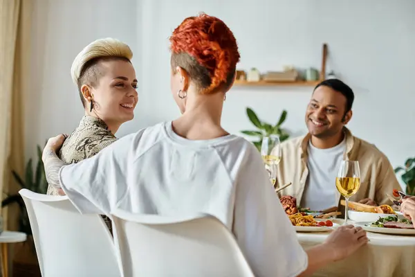 Diverso grupo disfrutando de la cena en casa, incluyendo una pareja lesbiana cariñosa. — Stock Photo