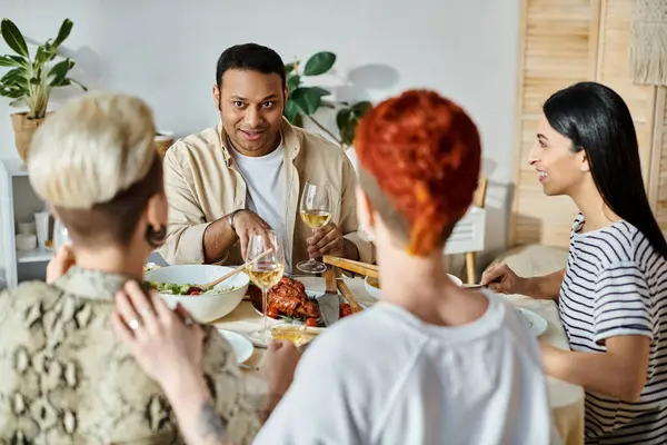 Amigos multiculturais e um casal lésbico que gosta de jantar juntos em casa. — Fotografia de Stock