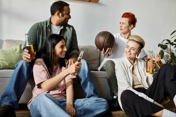 Diverse group of friends chatting and enjoying each other company while seated on a couch. — стоковое фото