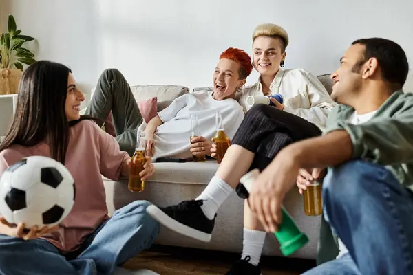Разнообразные друзья и любящая лесбийская пара отдыхают вместе на диване дома. — стоковое фото