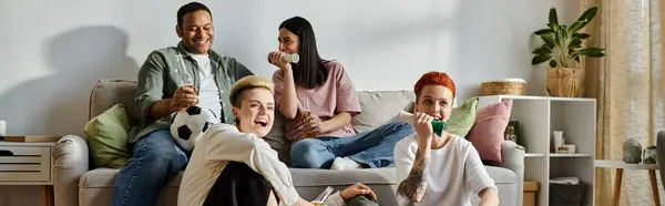 Diverso grupo de amigos relajándose en el sofá, compartiendo risas y alegría. - foto de stock