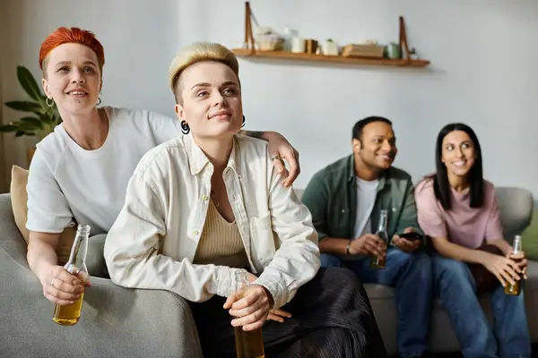 Diverse group of friends, with a loving lesbian couple, relax and converse on top of a couch. — Stock Photo