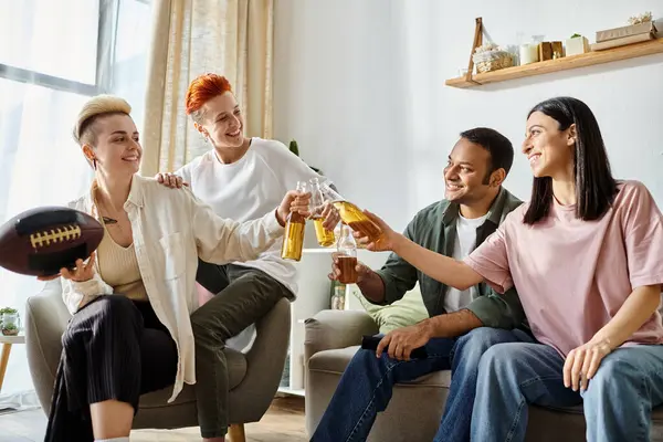 Groupe diversifié dégustant de la bière sur un canapé. — Photo de stock