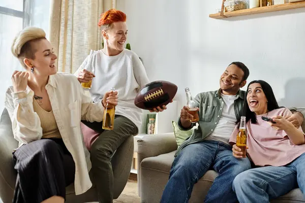 Diverse group on couch, laughing and drinking. — Stock Photo