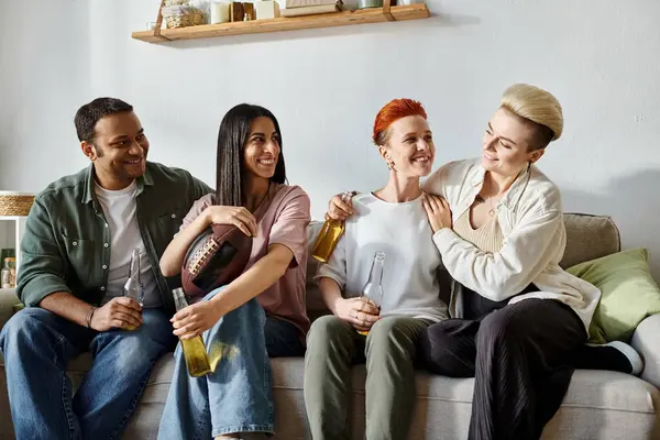 Diverse friends and a loving lesbian couple enjoy each others company on a comfy couch. — Stock Photo