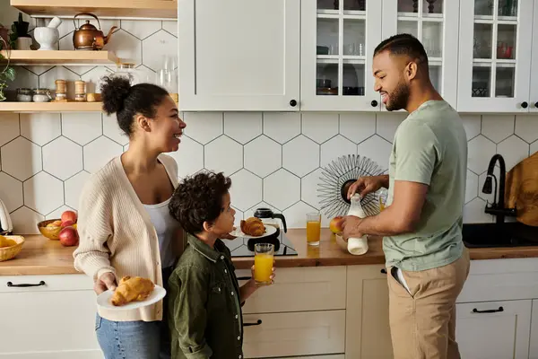 Man, woman, and boy share joyful moment in kitchen. — Stock Photo