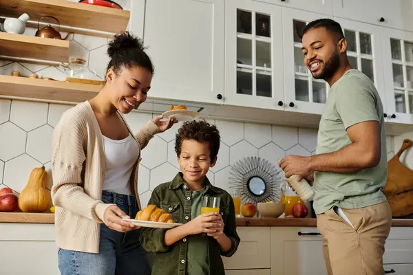 Ein Mann und eine Frau mit ihrem Sohn stehen glücklich in einer Küche. — Stockfoto