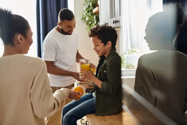 Una famiglia afroamericana che si gode il tempo insieme intorno al bancone della cucina. — Foto stock