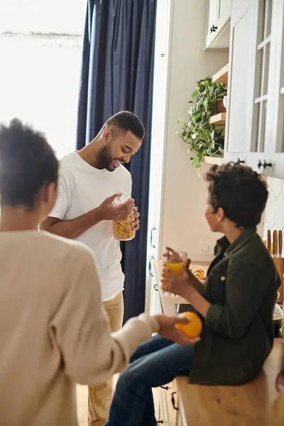 Vielfältige Familie unterhält sich angeregt am Küchentisch. — Stockfoto