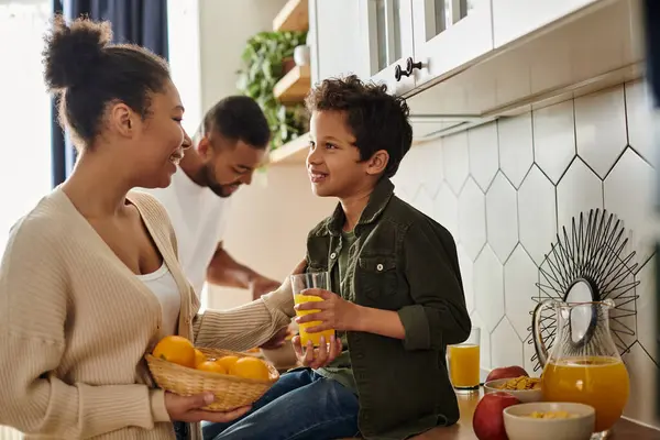 Woman holds oranges while standing next to a husband and son. — Stock Photo