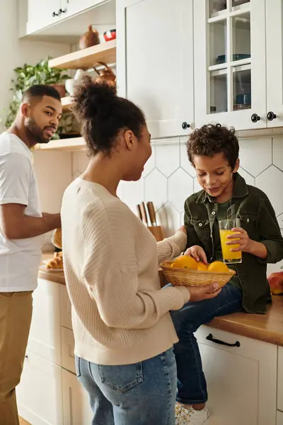 African American family sharing stories and laughter around a kitchen counter. — Stock Photo