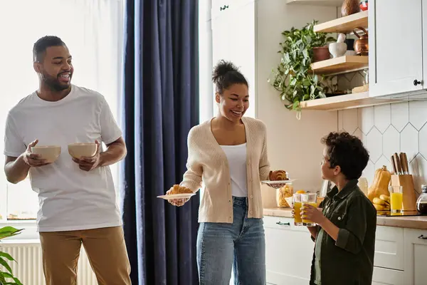 African American family, joyfully standing around in a kitchen. — Stock Photo