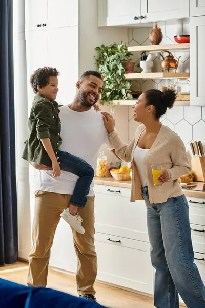 Uomo, donna e bambino afroamericani che si divertono insieme in cucina. — Foto stock