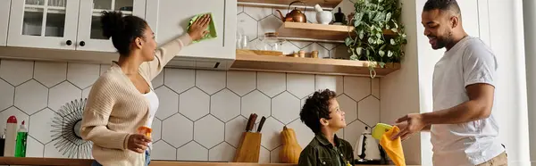 A man and a woman lovingly standing in a kitchen with child. — Stock Photo
