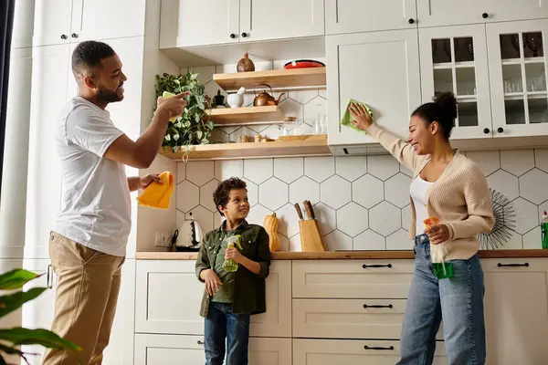 African american family happily cleaning together in the kitchen. — Stock Photo