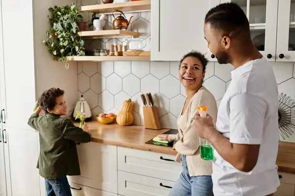 African American man and woman enjoying quality time in kitchen with son. — Stock Photo