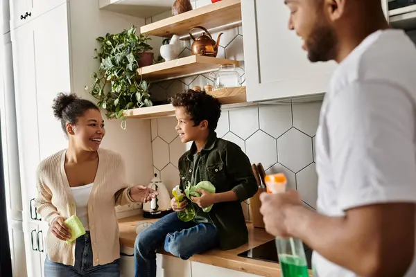 An African American couple cleaning together in a vibrant kitchen with son. — Stock Photo