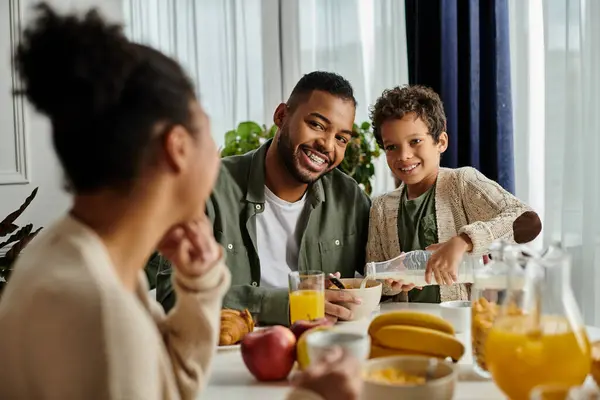 Close-knit African American family sharing food and conversation at the table. — Stock Photo