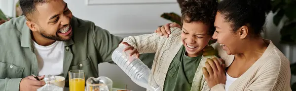 An African American family happily eating together around a table. — Stock Photo