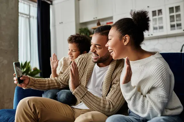 Loving African American family, sitting together on a vibrant blue couch. — Stock Photo
