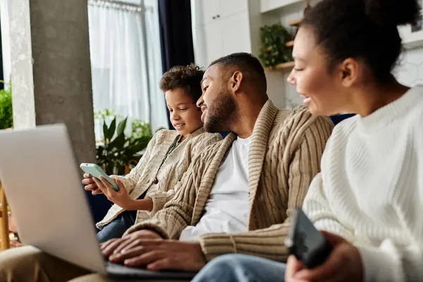 African american family engaged with laptop on couch. — Stock Photo