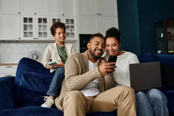 Famiglia afroamericana assorto in un telefono cellulare mentre seduto su un divano. — Foto stock