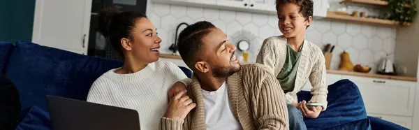 Afroamerikanische Familie sitzt zusammen, versunken in einem Laptop-Bildschirm. — Stockfoto