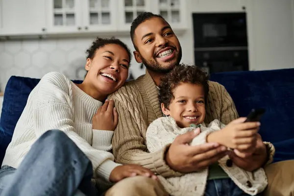 Man, woman, and child engrossed in cell phone together. — Stock Photo