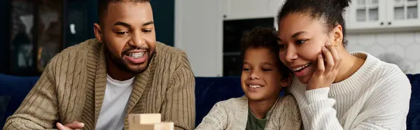 African American man and woman with child playing game. — Stock Photo