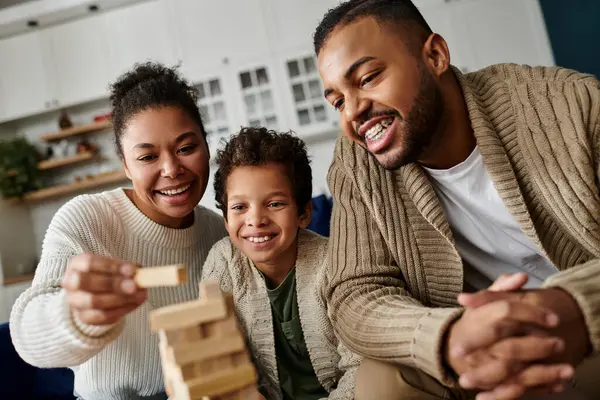 Man, woman, and child joyfully creating with wooden blocks. — Stock Photo