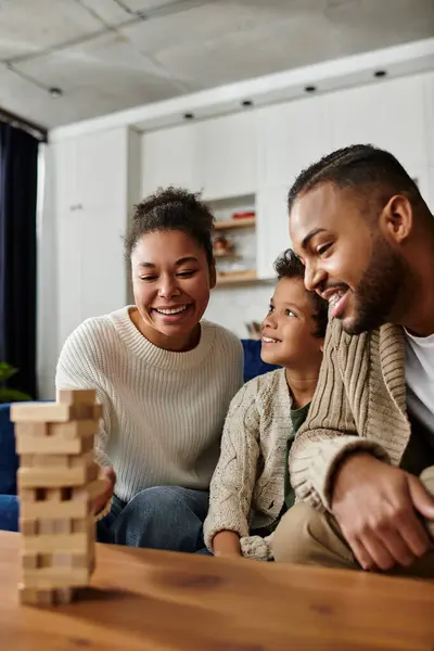 Happy African American family enjoying a game together on the couch. — Stock Photo