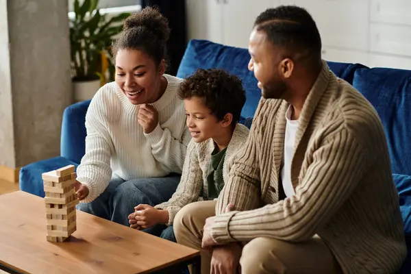 African American family enjoys playing a game together on the couch at home. — Stock Photo