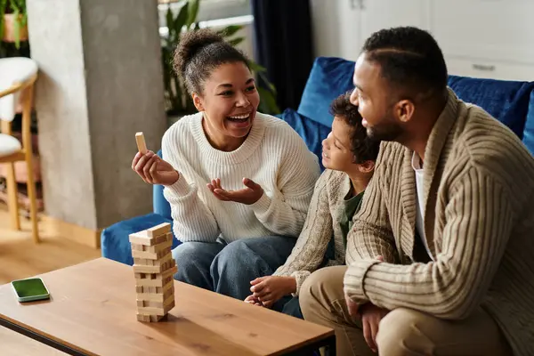 African american family joyfully constructing structures with wooden blocks. — Stock Photo