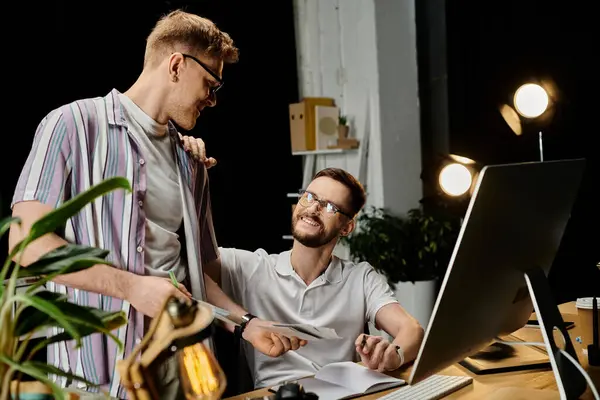 Two men in stylish attire collaborate on a laptop at a modern desk. — Stock Photo