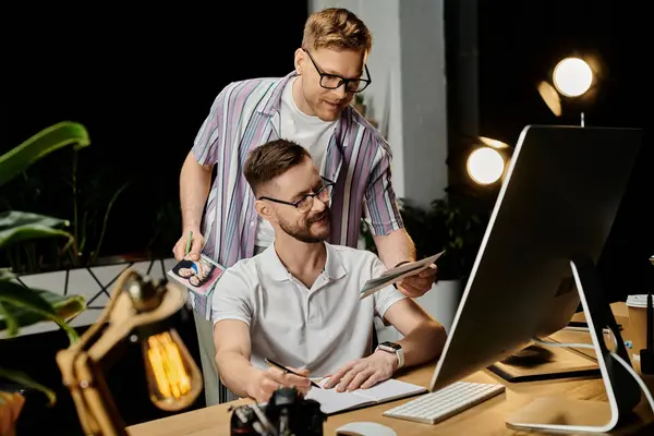 Two men in office attire looking attentively at a computer screen. — Stock Photo