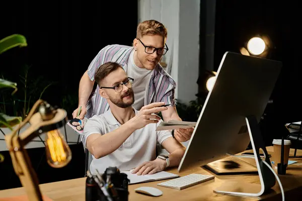 Two men in office attire engage with a computer screen. — Stock Photo