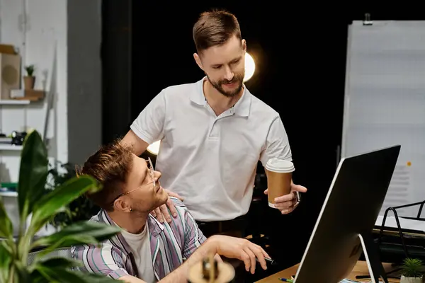 Zwei Männer in legerer Kleidung studieren in einem Büro Daten auf einem Computerbildschirm. — Stockfoto