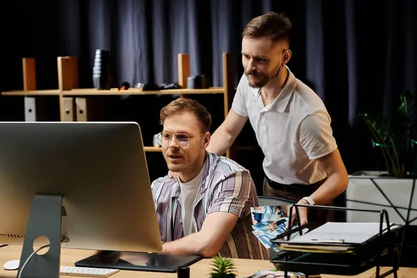 Two men engaged, captivated by data on a screen. — Stock Photo