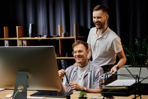 Man sitting at desk in front of computer next to his partner. — Stock Photo