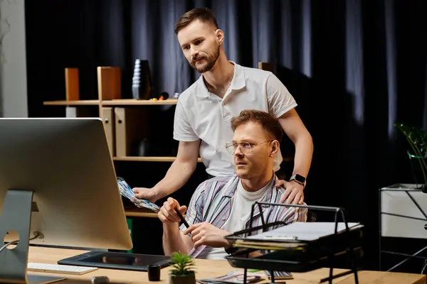 Zwei Männer in Freizeitkleidung arbeiten gemeinsam an einem Computer im Büro. — Stockfoto