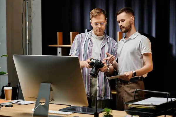 Two men engrossed in a computer screen, collaborating in a cozy office setting. — Stock Photo