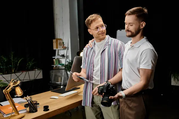 Two men in casual attire working side by side at a desk. — Stock Photo