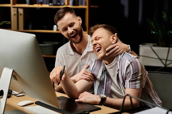 Dois homens, de traje casual, sentam-se juntos na frente de um computador trabalhando. — Fotografia de Stock