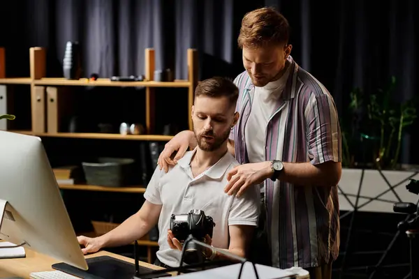 Two men in casual attire, focused on a computer screen in an office setting. — Stock Photo