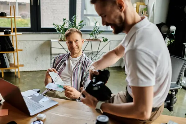 Happy couple working together at a table in an office setting. — Stock Photo