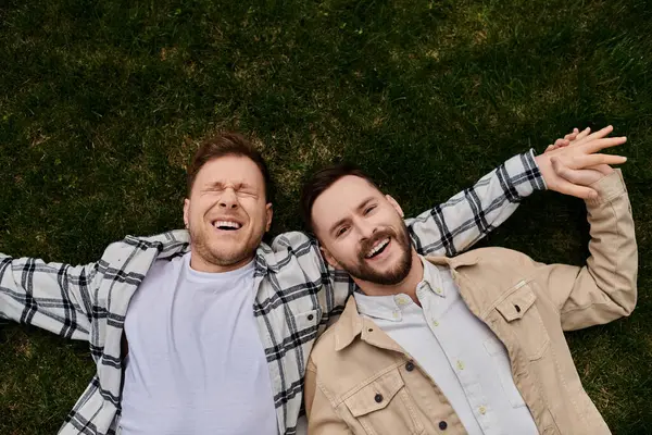 Two men relaxing on a vibrant green field. — Stock Photo