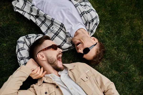 Two men laying on lush green field. — Stock Photo