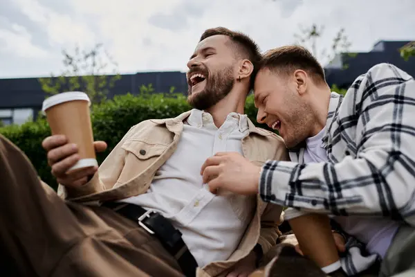 Due uomini in abbigliamento accogliente condividono un momento di felicità all'aperto. — Foto stock