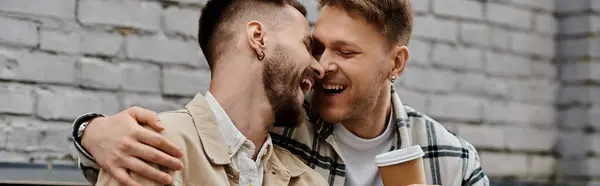 A gay couple in casual clothing standing happily together outdoors. — Stock Photo